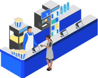 Cinema concessions counter with a staff member serving a customer beside snacks and drinks.
